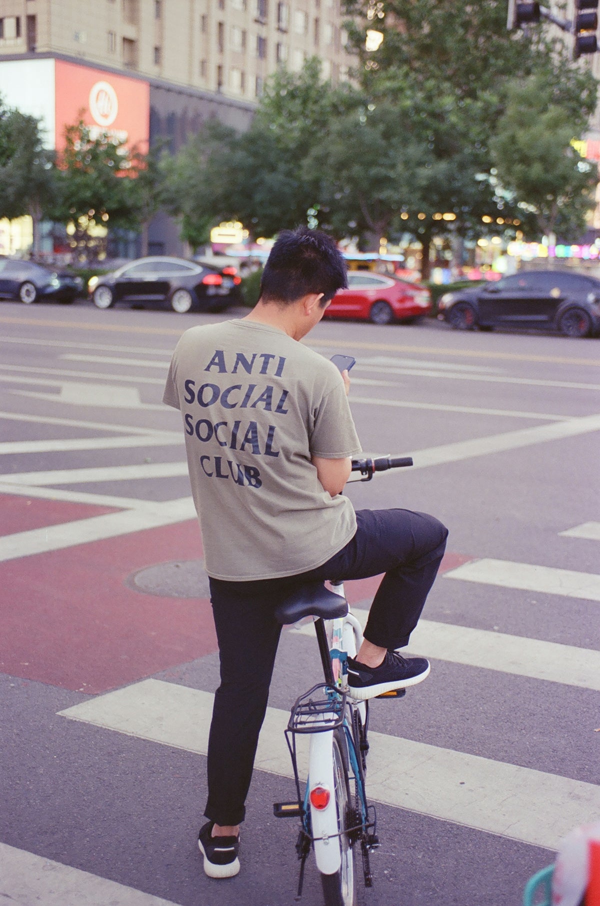 Man wearing anti social social club shirt on bicycle